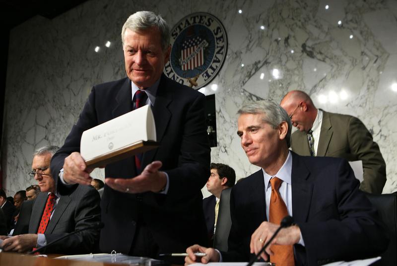 Committee members Sen. Max Baucus (D-MT) (L) sets his name plate up as Sen. Rob Portman (R-OH) (R) looks on during a hearing before the Joint Deficit Reduction Committee.